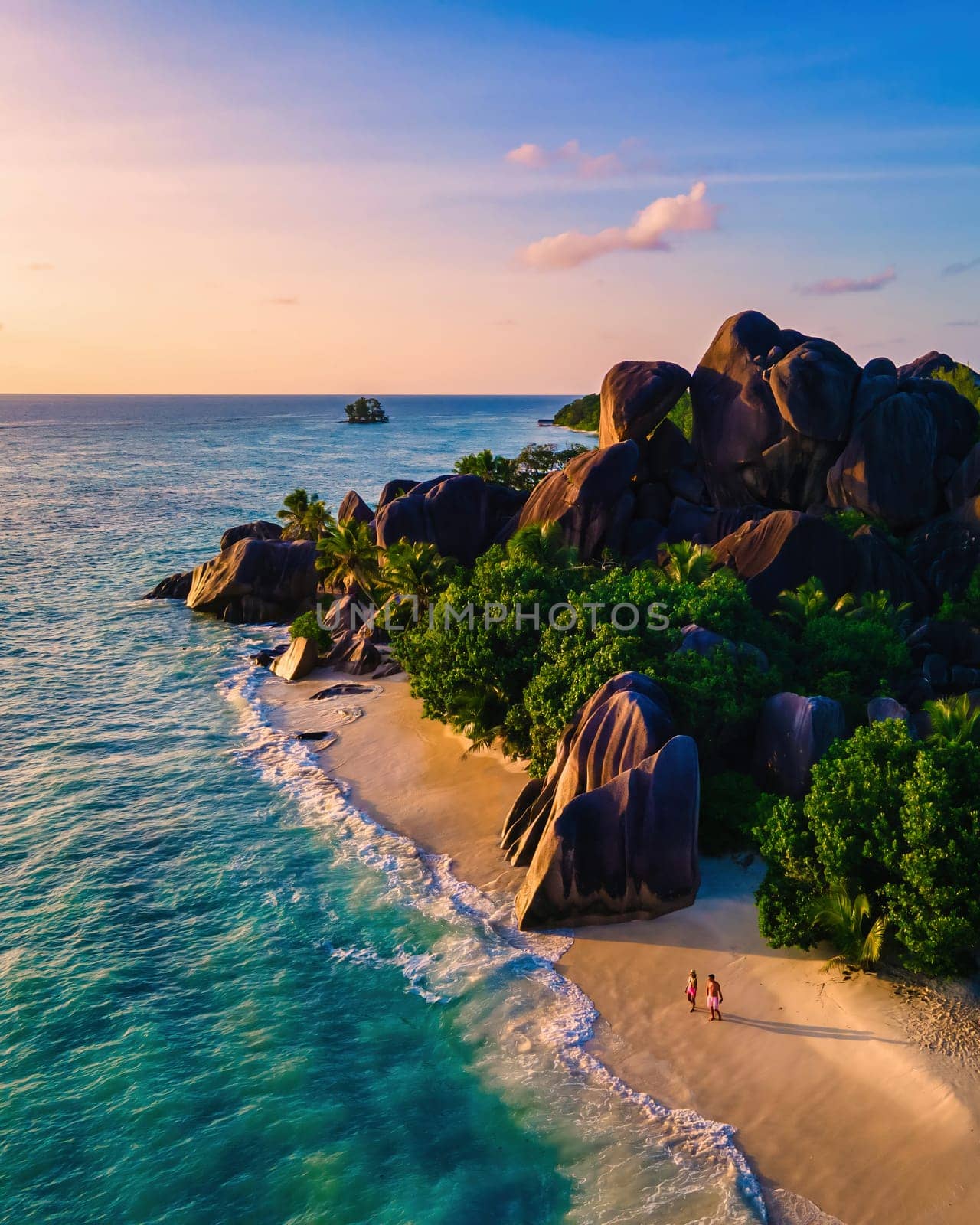 Anse Source d'Argent beach La Digue Island Seychelles, Drone aerial view of La Digue Seychelles bird eye view of tropical Island, couple men and woman walking at the beach during sunset