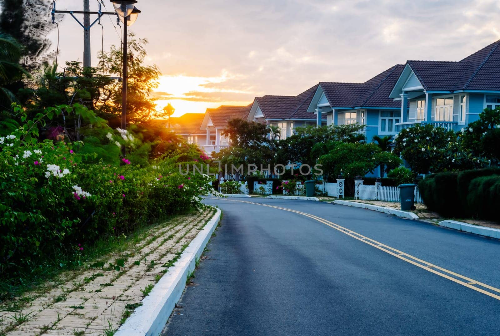 Modern cottages row road sidewalk two story buildings residential villas village New Estate Reflection dawn Sun in windows.