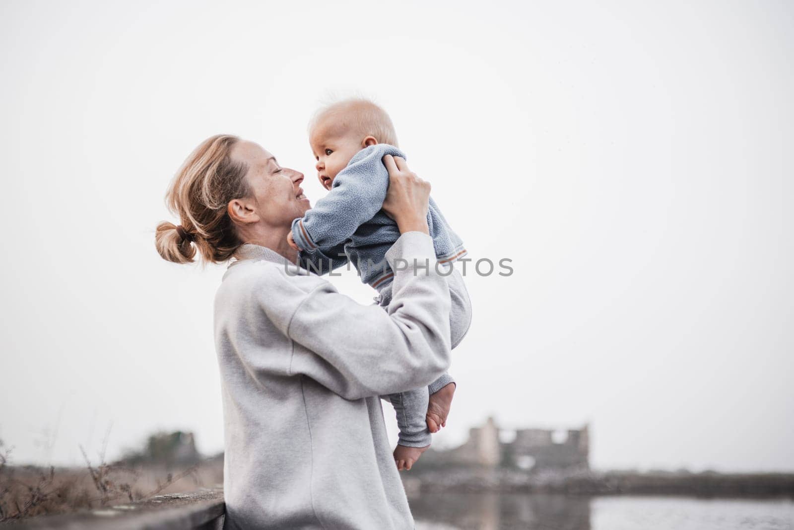 Tender woman caressing her little baby boy infant child outdoors on autumn trip to Secovlje salinas landscape park, Slovenia. Mother's unconditional love for her child. by kasto