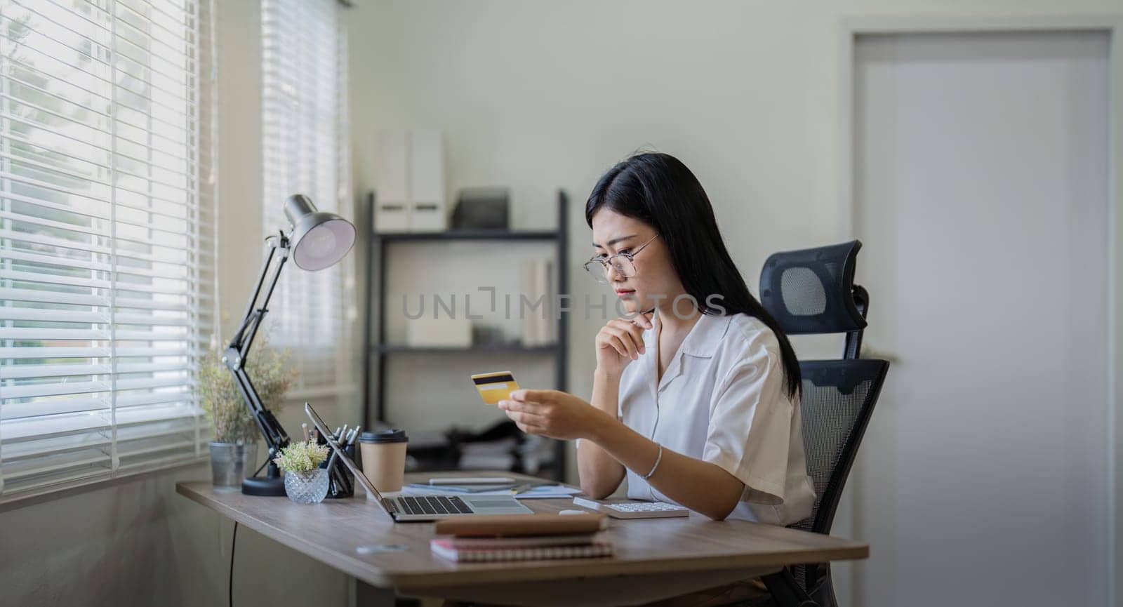 Woman on desk with laptop, credit card and ecommerce payment for online shopping at home. Happy female customer, digital bank app and sale on store website with internet banking by nateemee