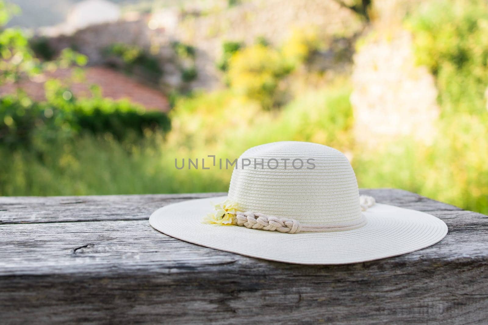 Summer nature background. Braided straw hat on bench in garden. spring season. Rustic composition nature. Relax voyage time. Copy space and mock up place for text by Satura86