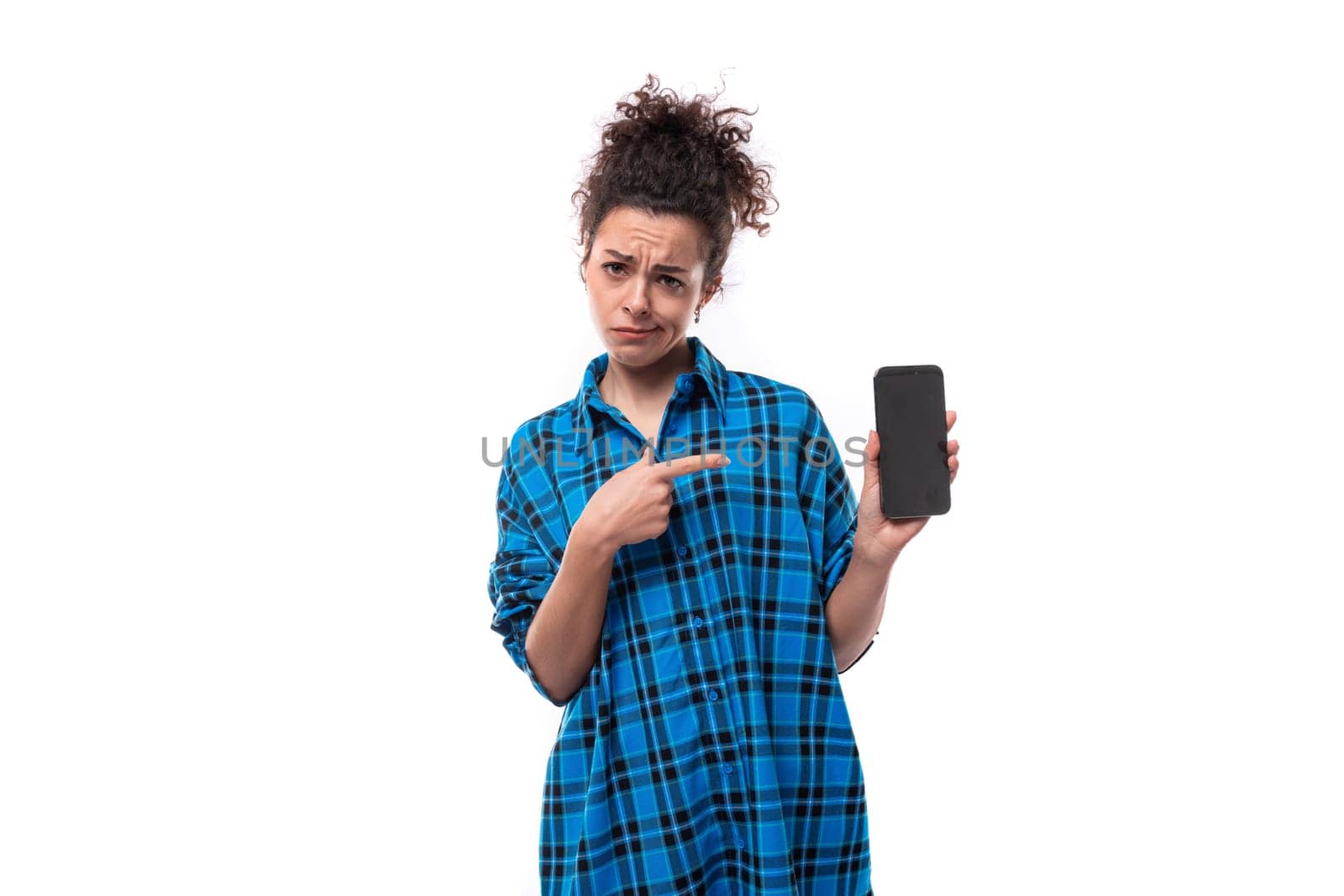 european young lady with curly ponytail hair style showing ads on mobile phone.