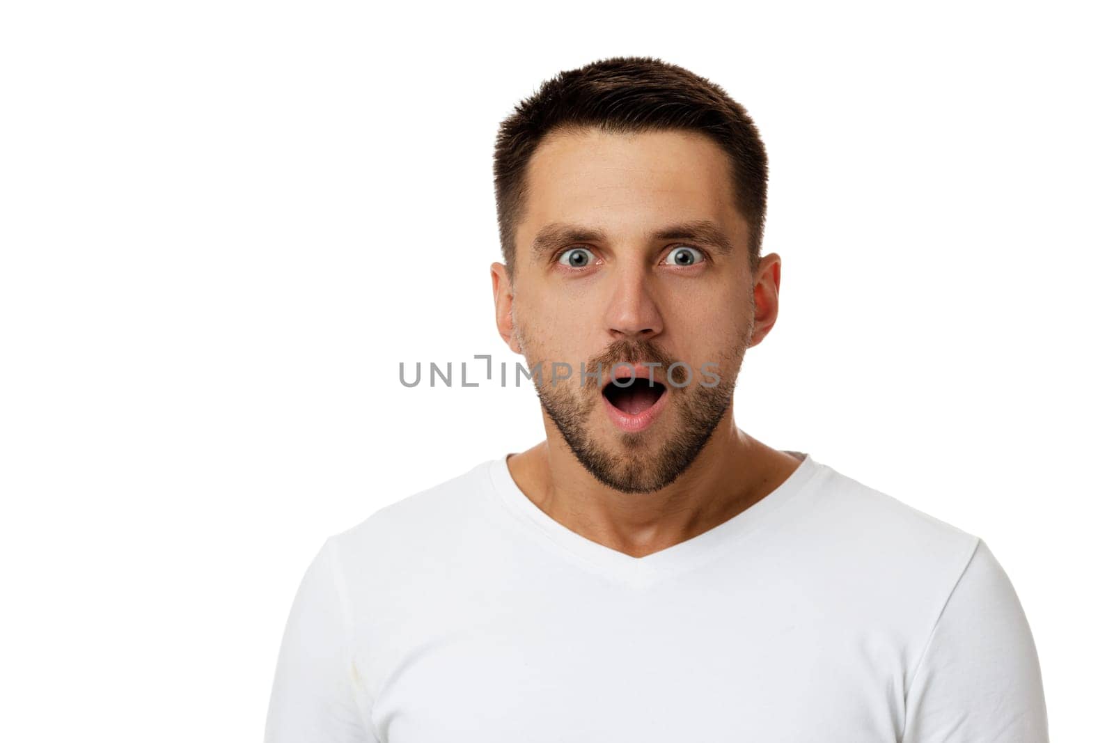 Portrait of young surprised handsome bearded man with shocked facial expression on white background