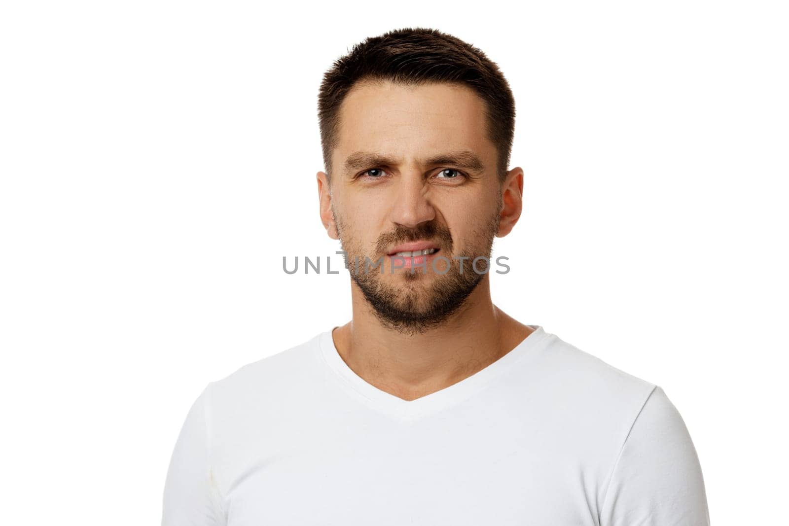 Portrait of young frowned handsome bearded man on white background. facial expression