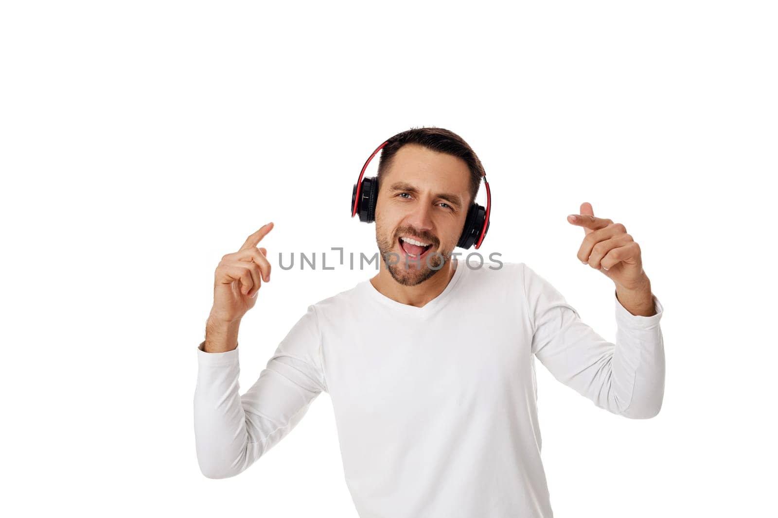 handsome smiling young man in headphones listening to music, dancing and singing isolated on white background.