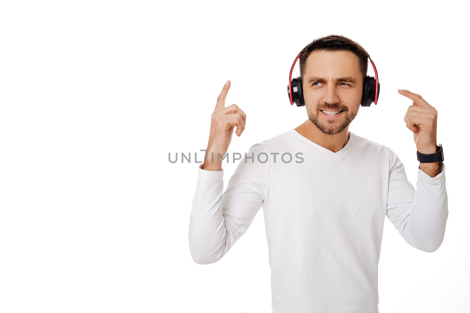 handsome smiling young man in headphones listening to music, dancing and singing isolated on white background.