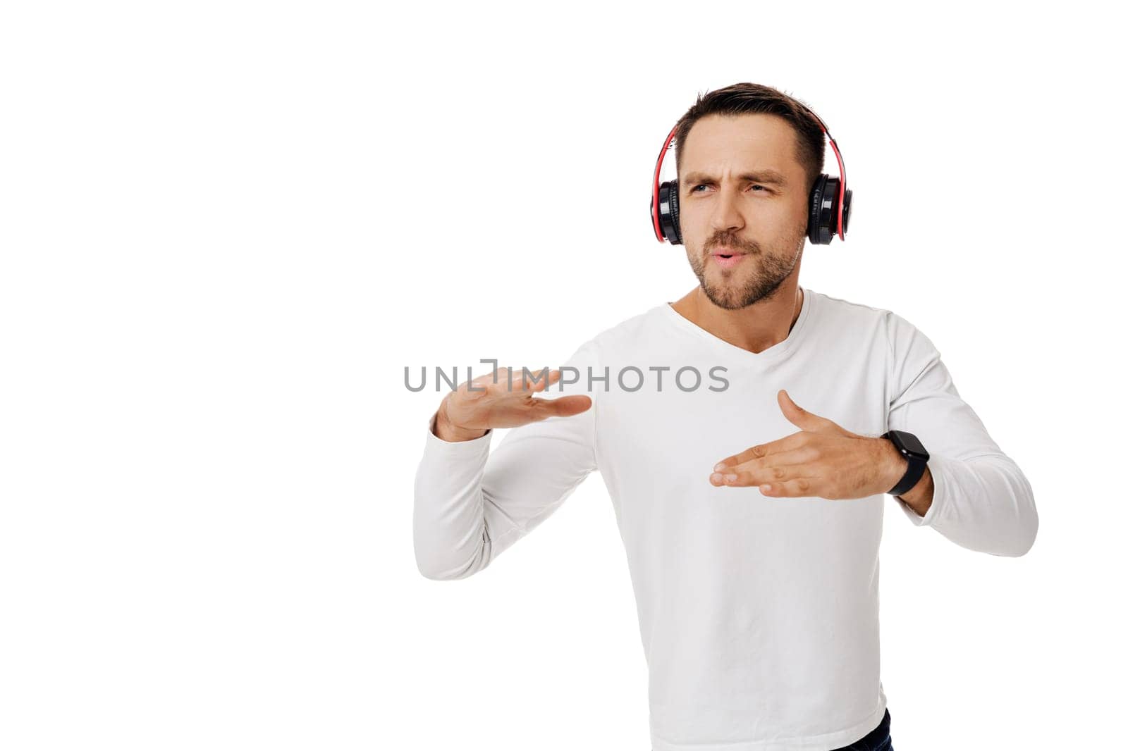 handsome young man in headphones listening to music and dancing isolated on white background.