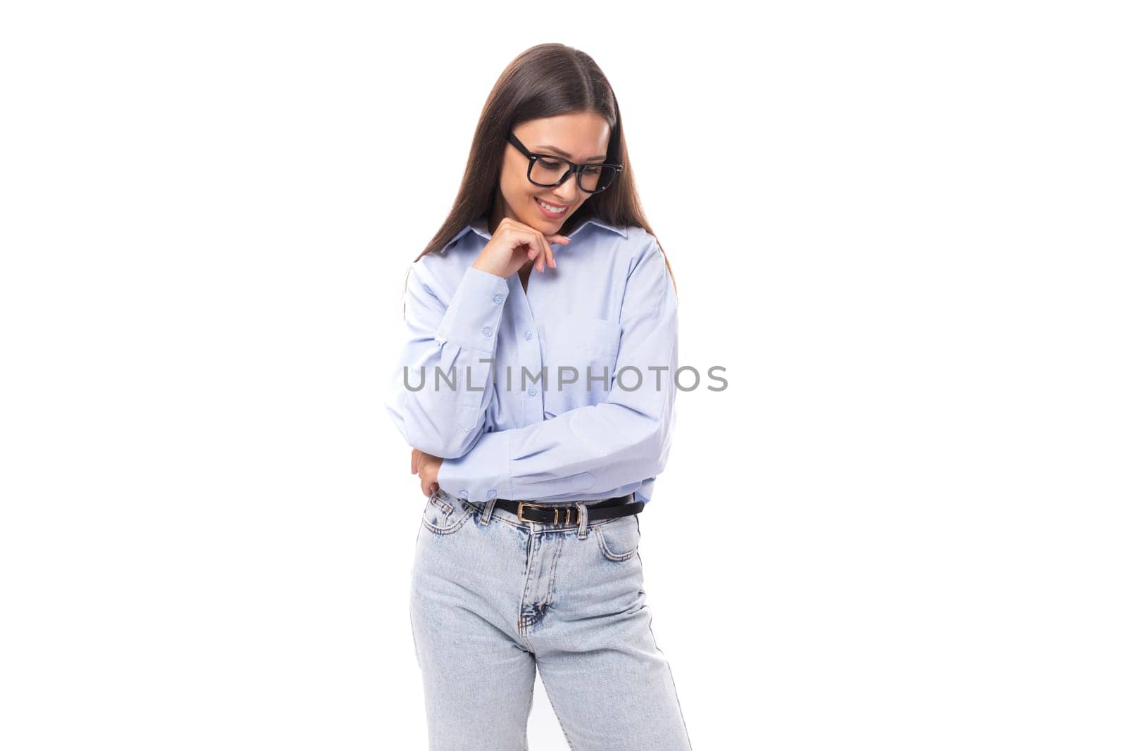 young pretty european brunette business woman with light makeup in a light blue blouse wears glasses for an image to work on a white background with copy space by TRMK