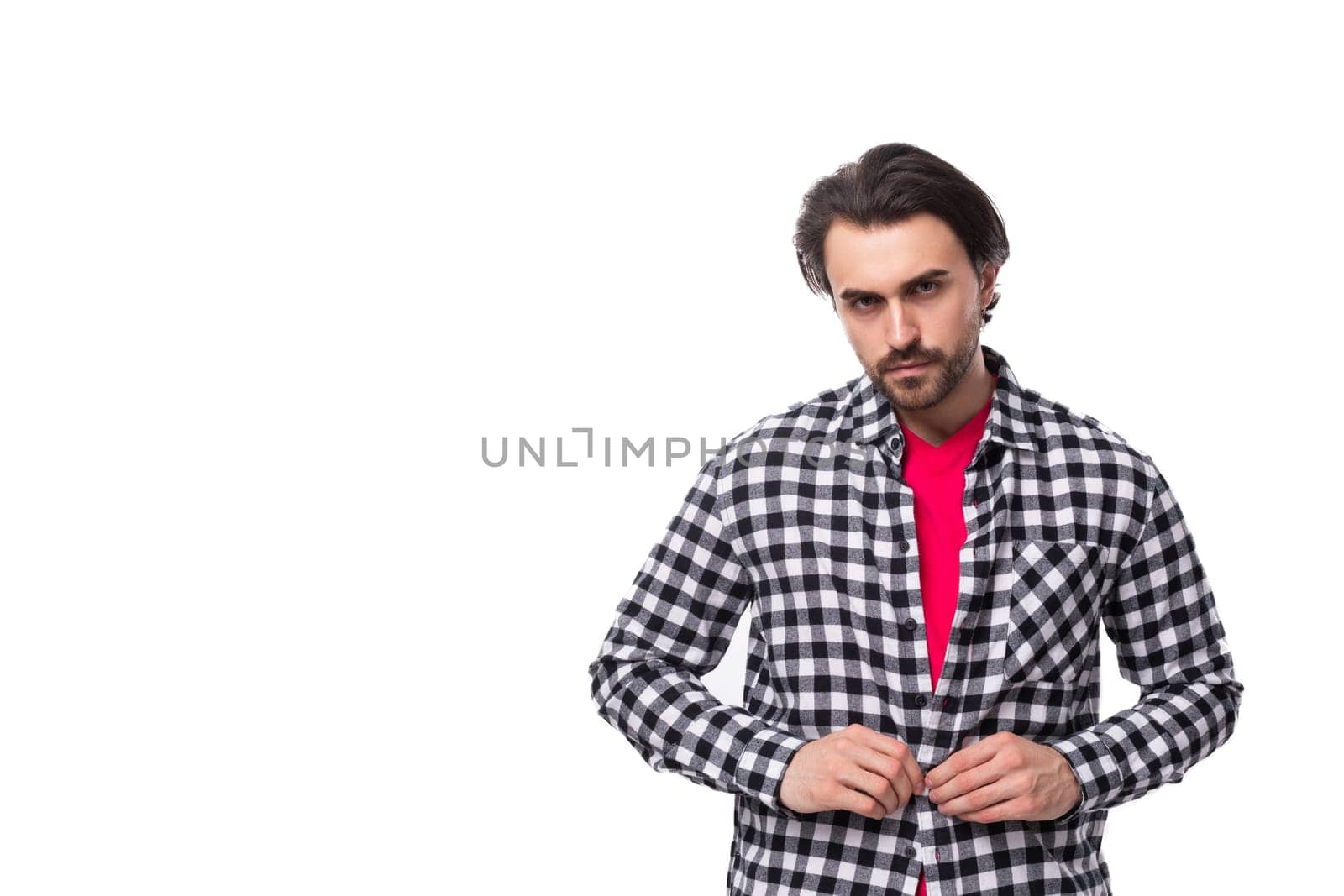 young european man with black hair and unshaven beard in a shirt on a white background with copy space.