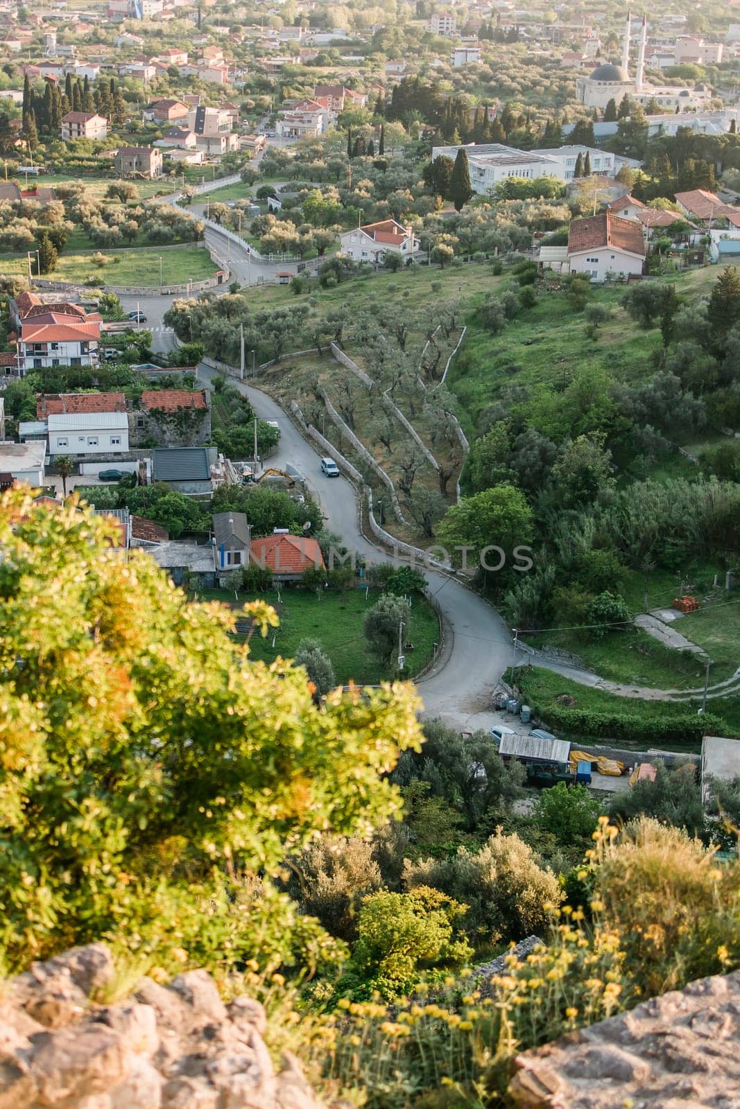 Mosque and panoramic cityscape of town Bar in Montenegro with road and houses, aerial view by Satura86