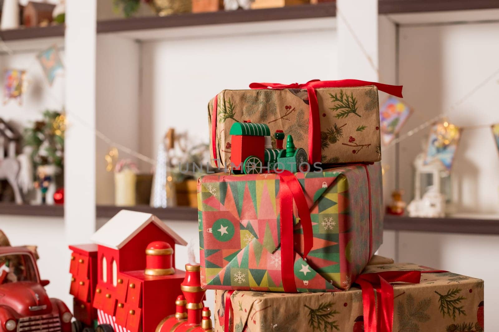 Stacks of Christmas presents under a Christmas tree with defocused lights
