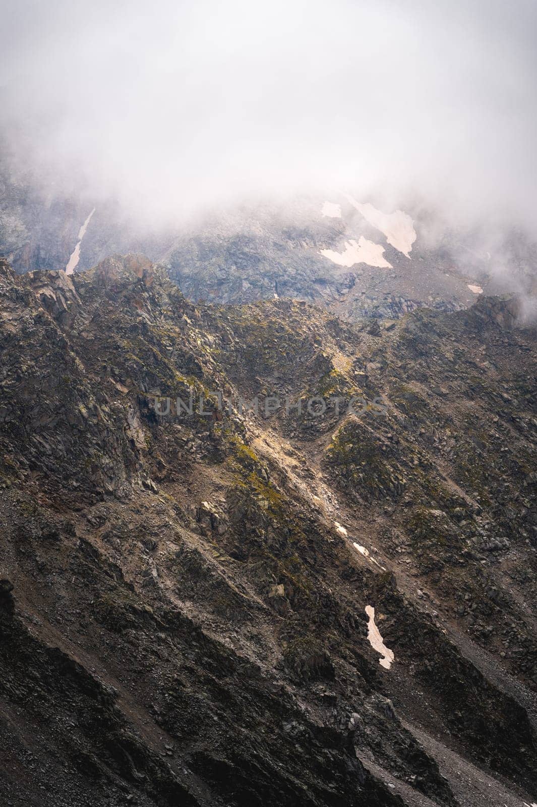 Close-up of a mountain wall at daytime against the backdrop of cumulus clouds by yanik88