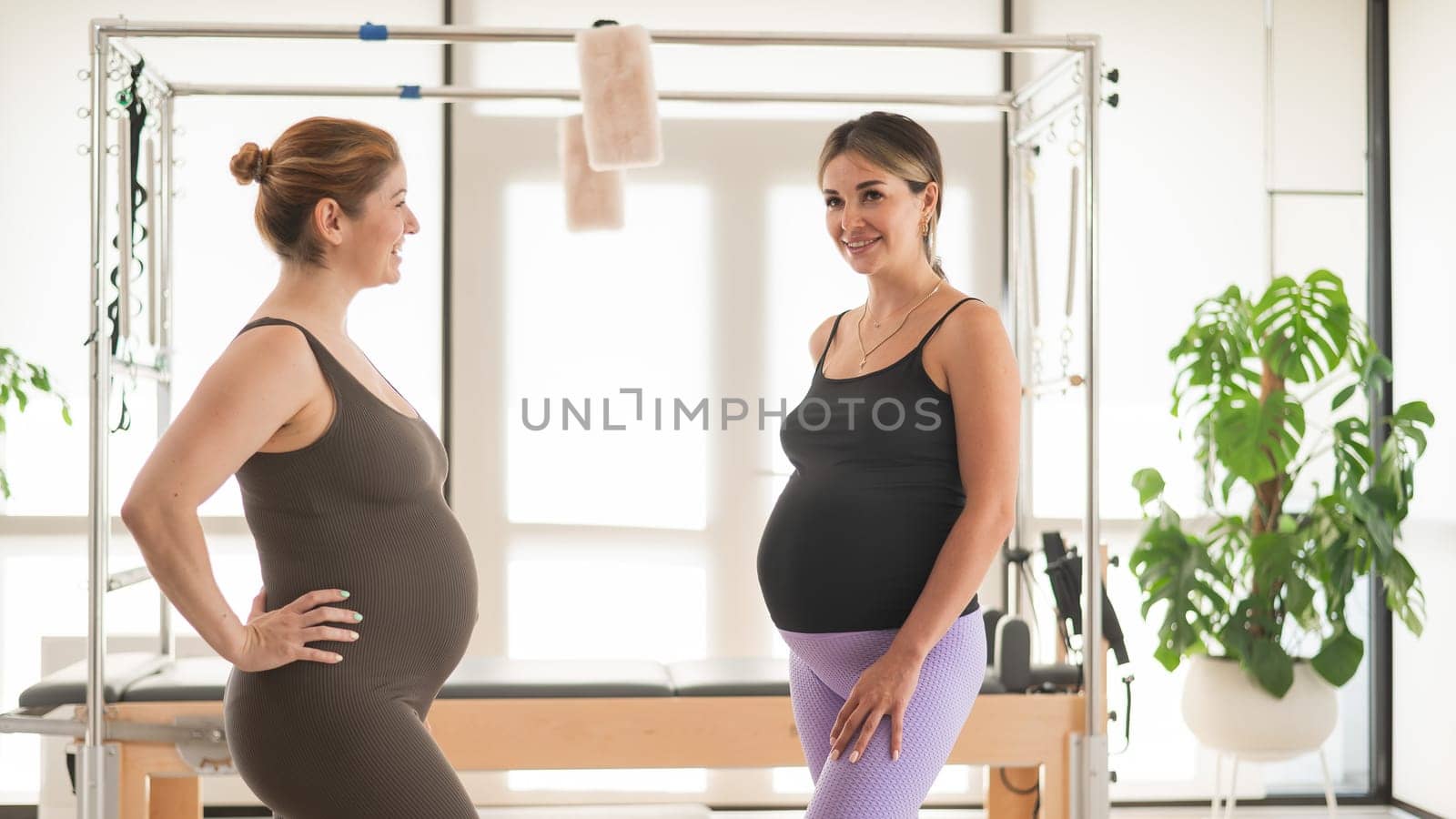 Two pregnant women walk from a Pilates class for expectant mothers
