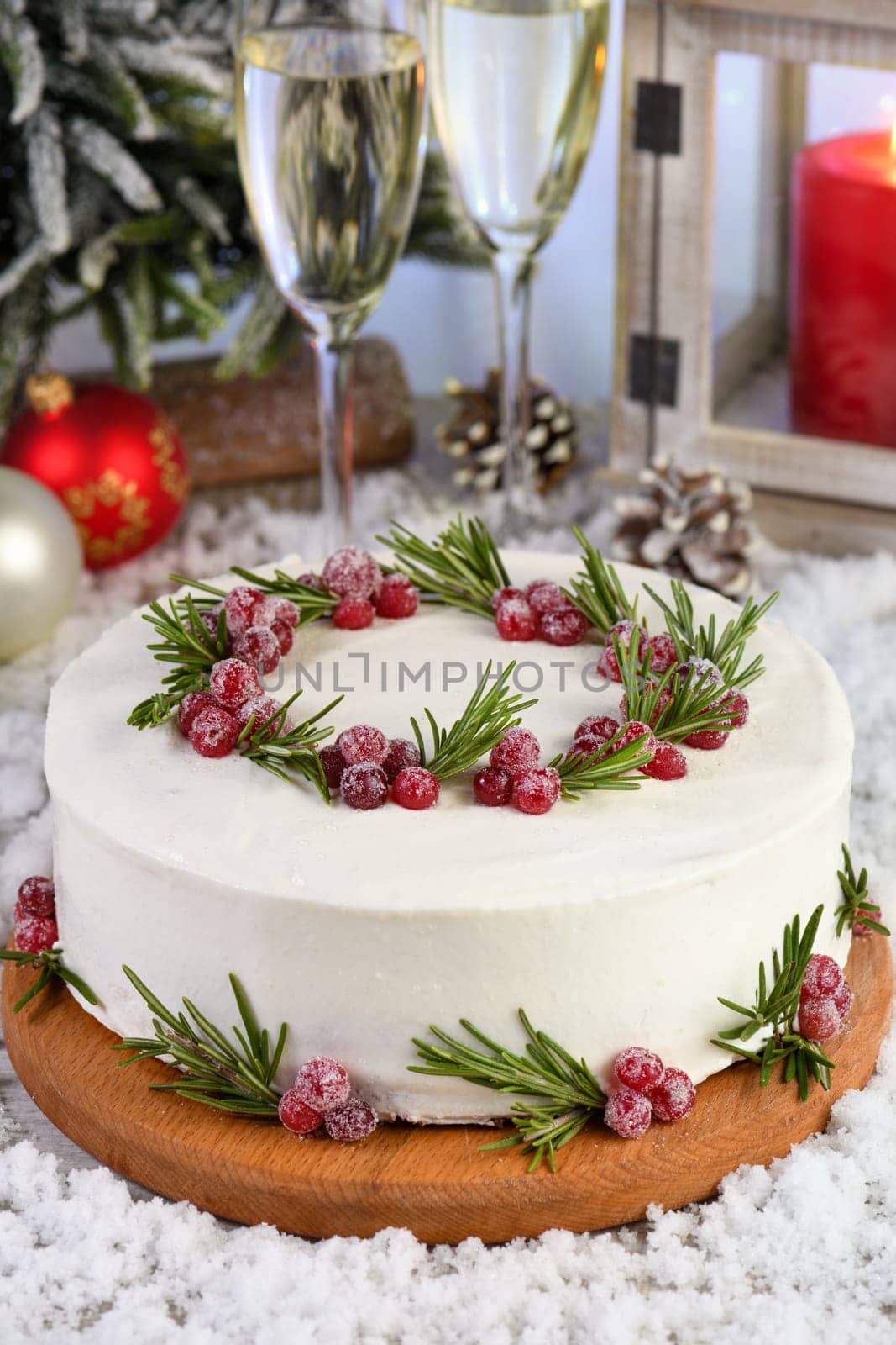 Red Velvet Cake is a traditional red chocolate cake topped with white buttercream and decorated with a Christmas wreath of candied cranberries and rosemary.