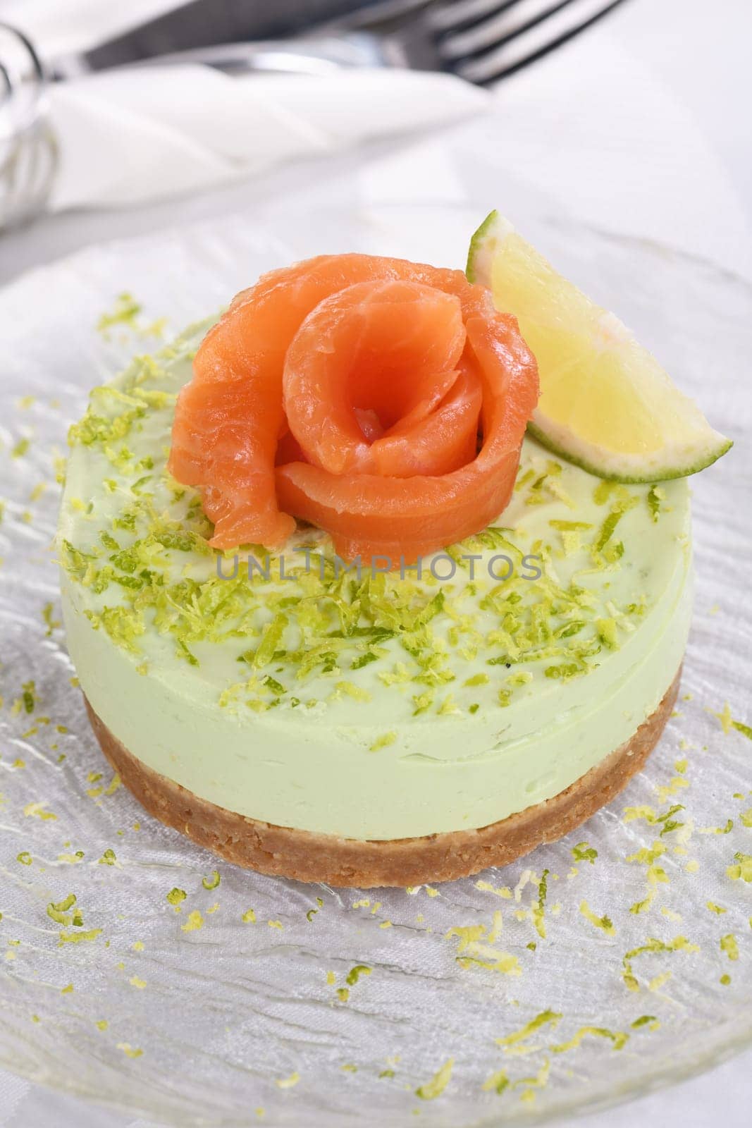 Timbale appetizer made from avocado, whipped with soft cheese cream and lime on short crust pastry with salmon. A great option for a holiday menu.