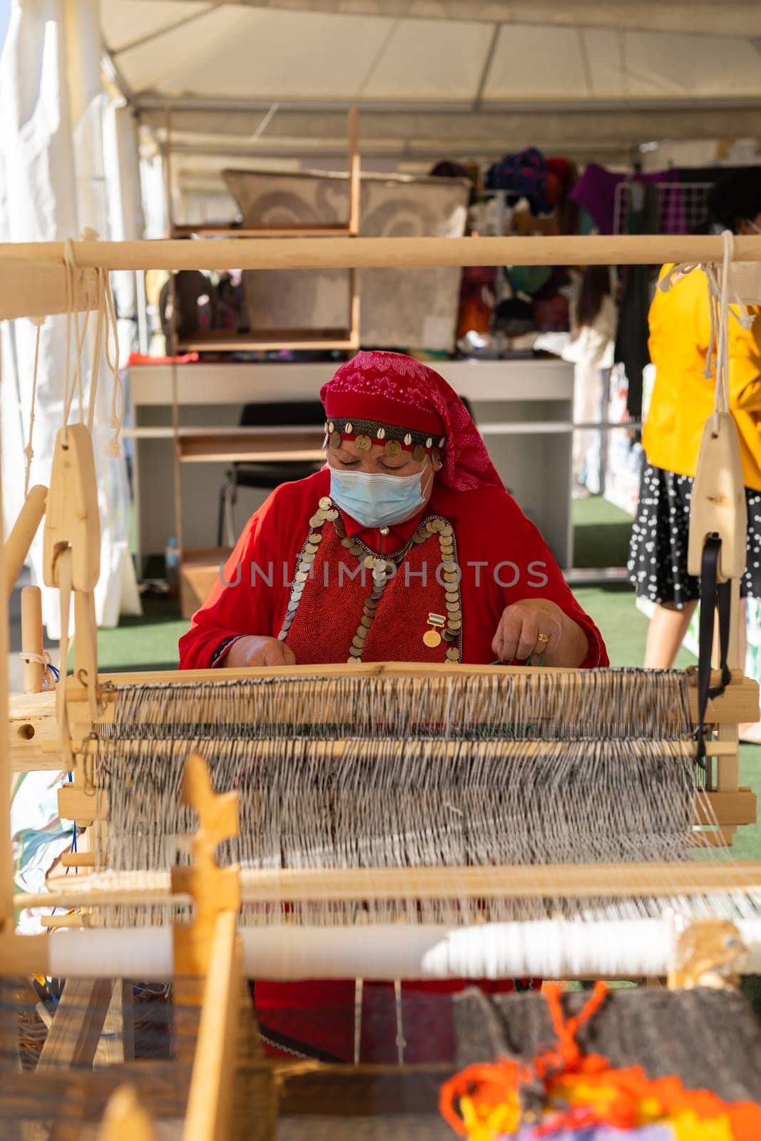 UFA, RUSSIA - JULY 10, 2021: Bashkir woman make carpet during Folkloriada by Satura86
