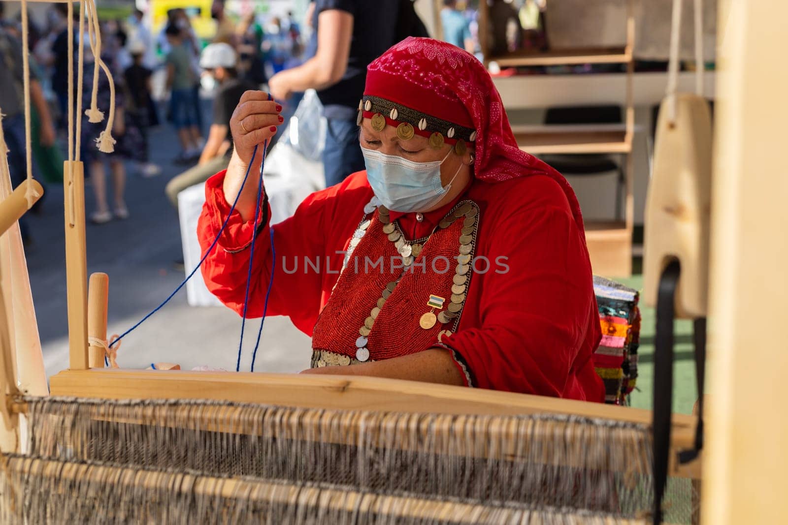 UFA, RUSSIA - JULY 10, 2021: Bashkir woman make carpet during Folkloriada by Satura86