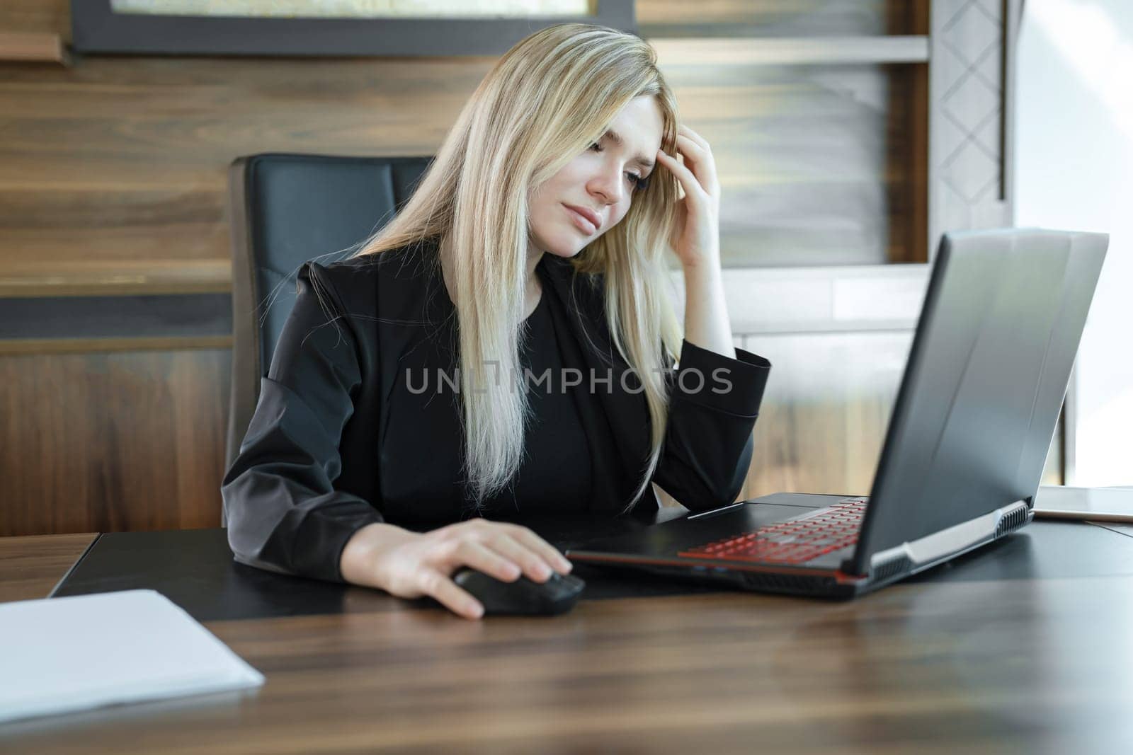 Focused girl blonde in black suit is sitting front of laptop in office, concept of online education and work by Laguna781