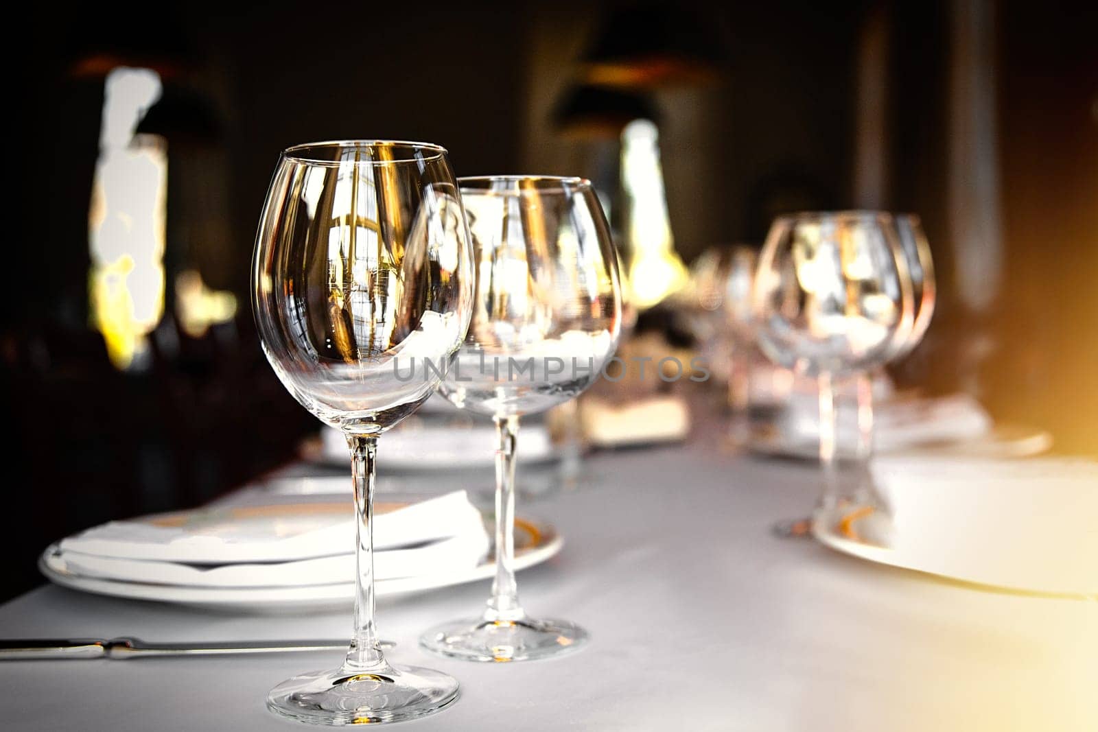 Served dinner table set in a luxury restaurant. Restaurant interior with window lighting by Rom4ek