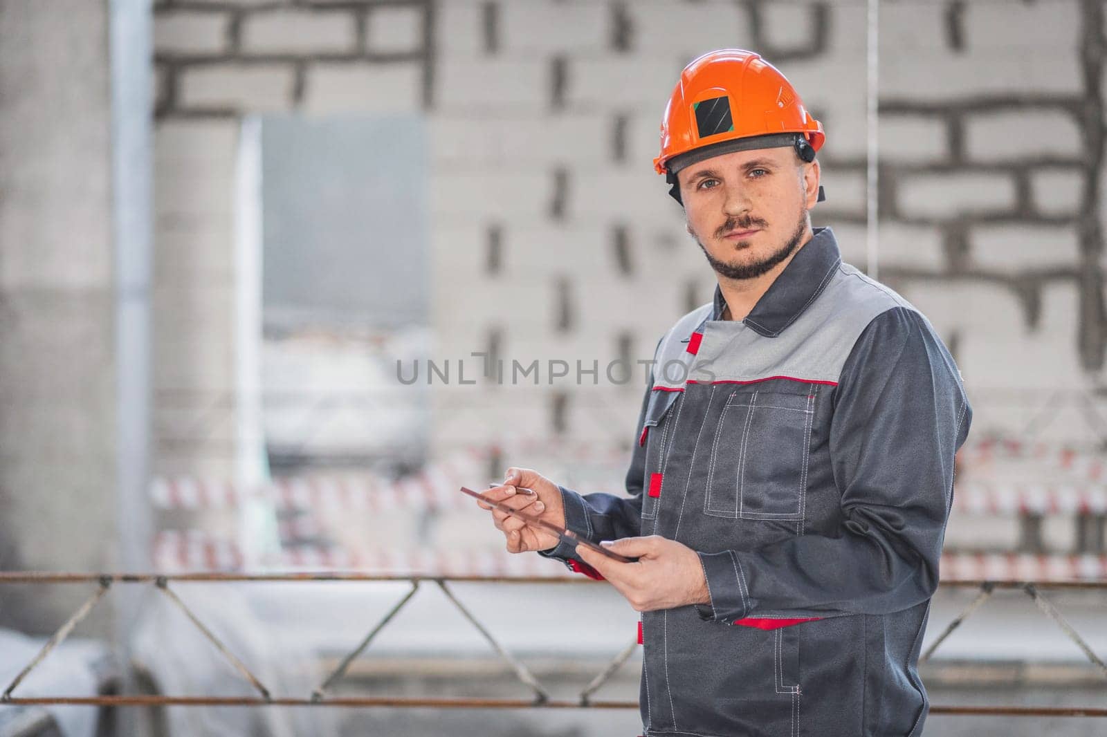 Caucasian construction foreman controlling building site with plan on digital tablet, copy space by Rom4ek