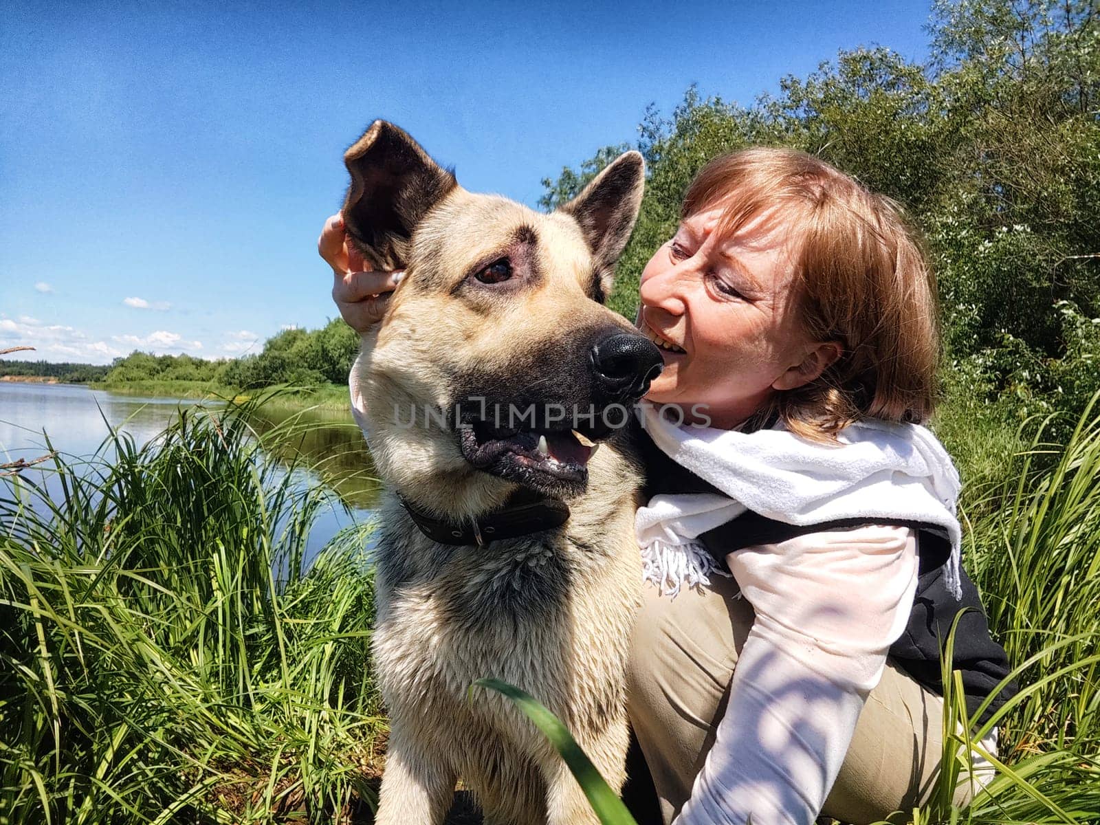 Dog German Shepherd and woman or girl in nature in summer, spring, summer day. Russian eastern European dog and the mistress, trainer veo outside and outdoors