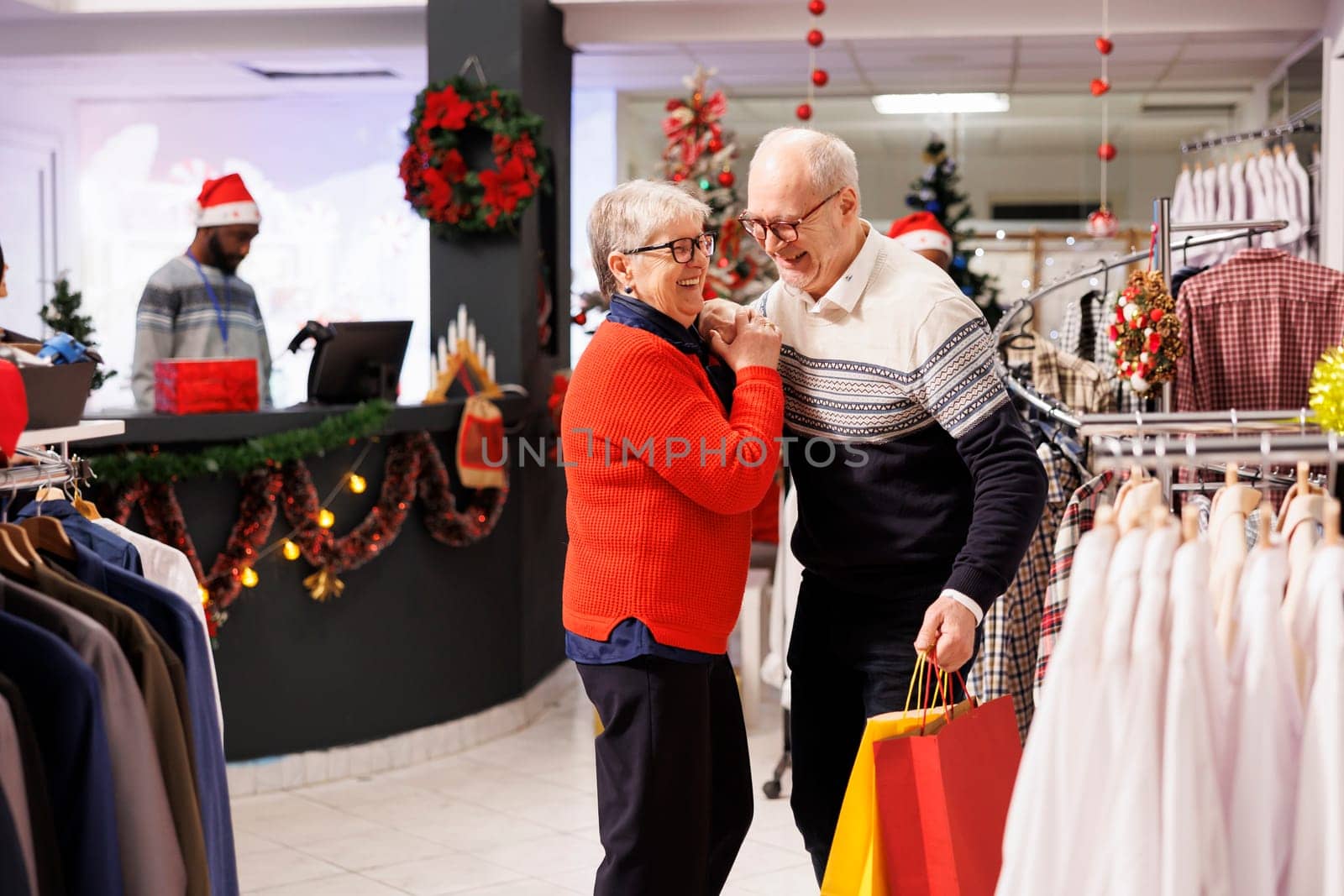 Elderly people doing sweet waltz dance in retail store, showing sincere feelings at mall during seasonal christmas promotions. Romantic man and woman dancing around in shopping center, xmas spirit.