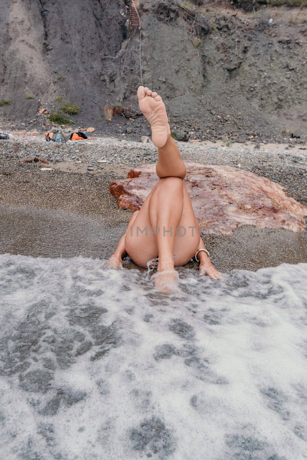 Woman summer travel sea. Happy tourist in blue bikini enjoy taking picture outdoors for memories. Woman traveler posing on the beach surrounded by volcanic mountains, sharing travel adventure journey by panophotograph