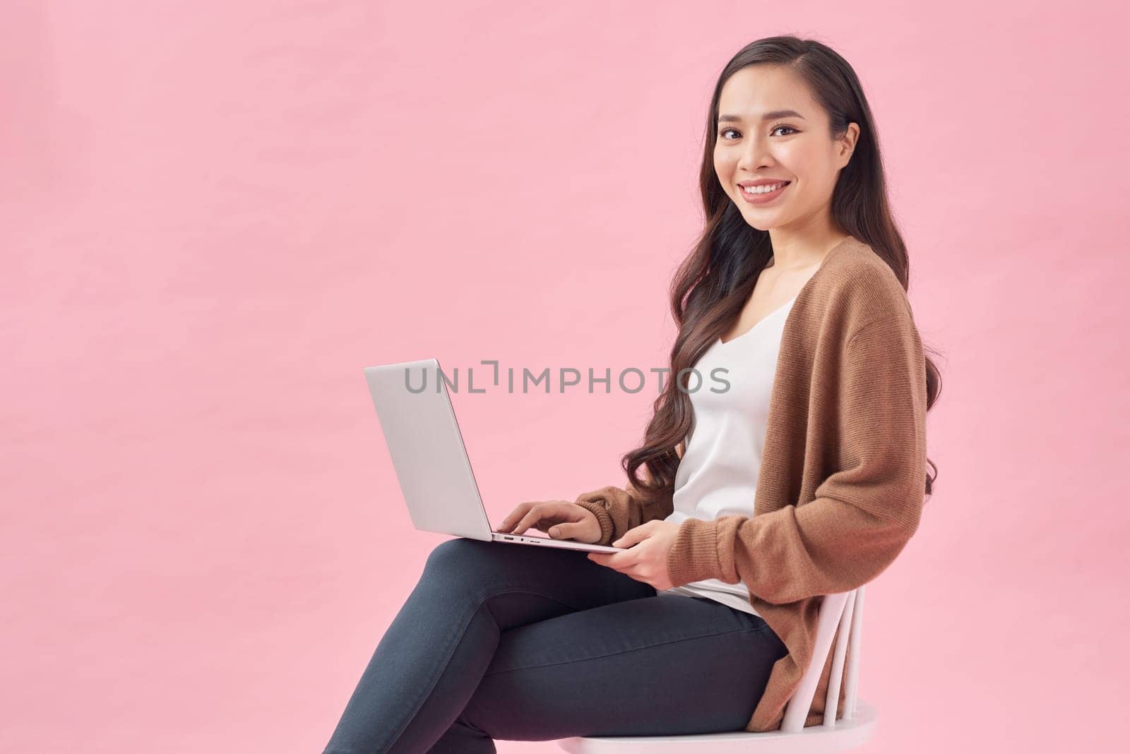 Dreamy millennial lady using portable pc for work, entertainment or online studies by makidotvn