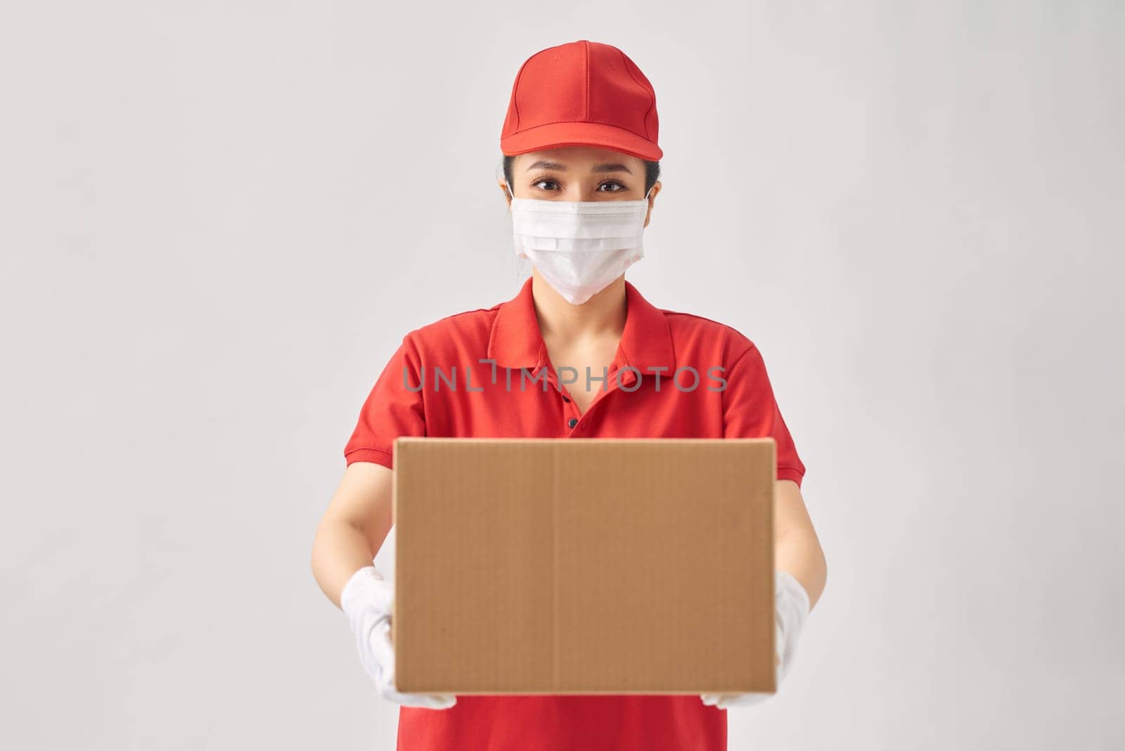 Female delivery courier in a red uniform smiling while working by makidotvn