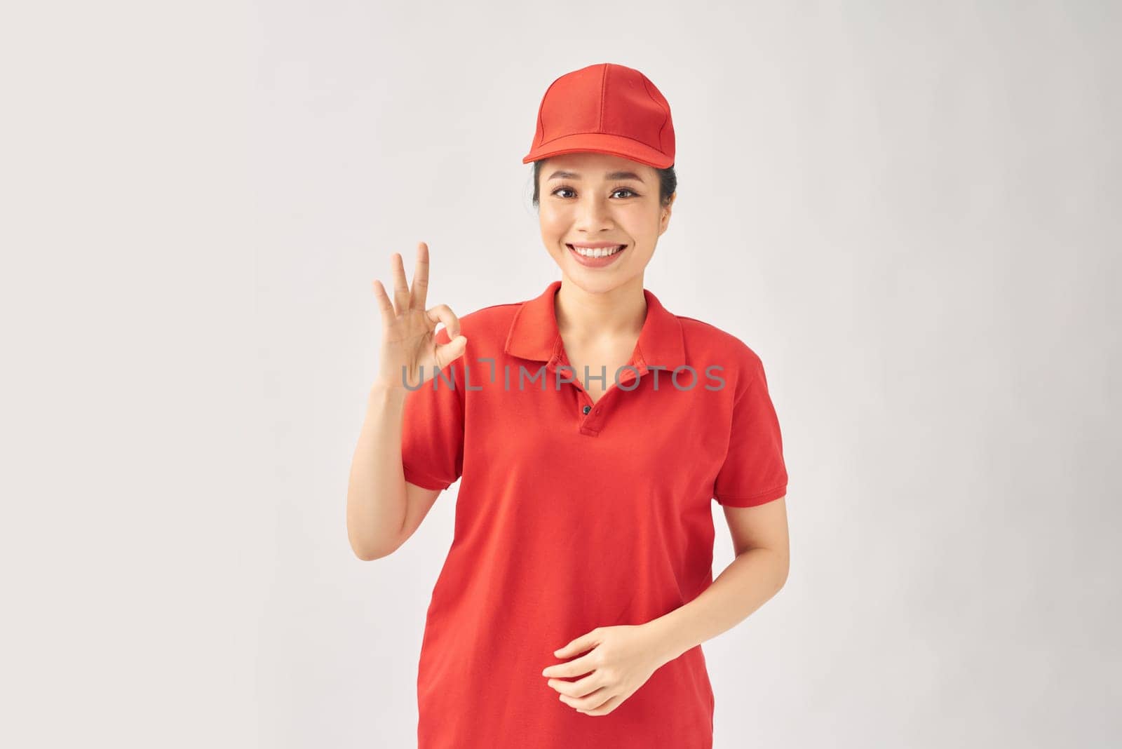 Delivery friendly woman in red uniform isolated on white background by makidotvn