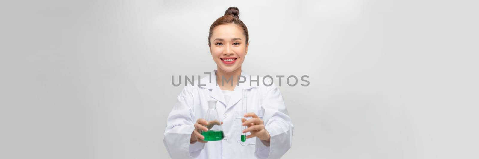 Female scientist in lab coat with chemical glassware. Isolated on white.