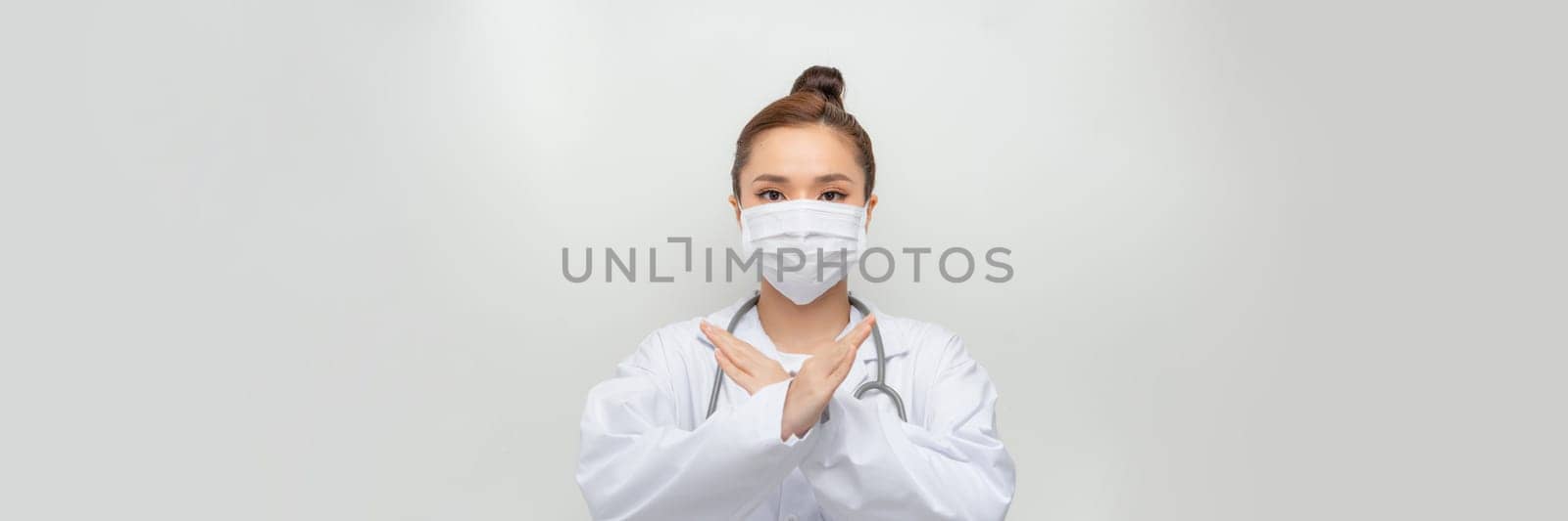 beauty female doctor in coat showing stop hand gesture by makidotvn