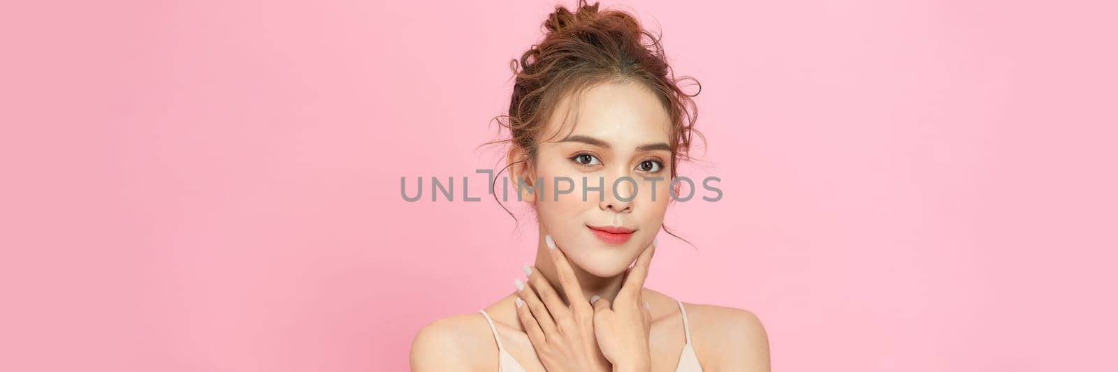 Close up face of beautiful woman posing isolated on pink color background by makidotvn