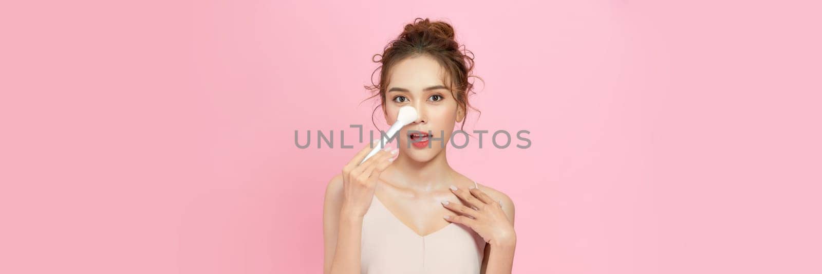 Beautiful Asian young woman smile and holding make up brush with healthy Clean and Fresh skin  by makidotvn