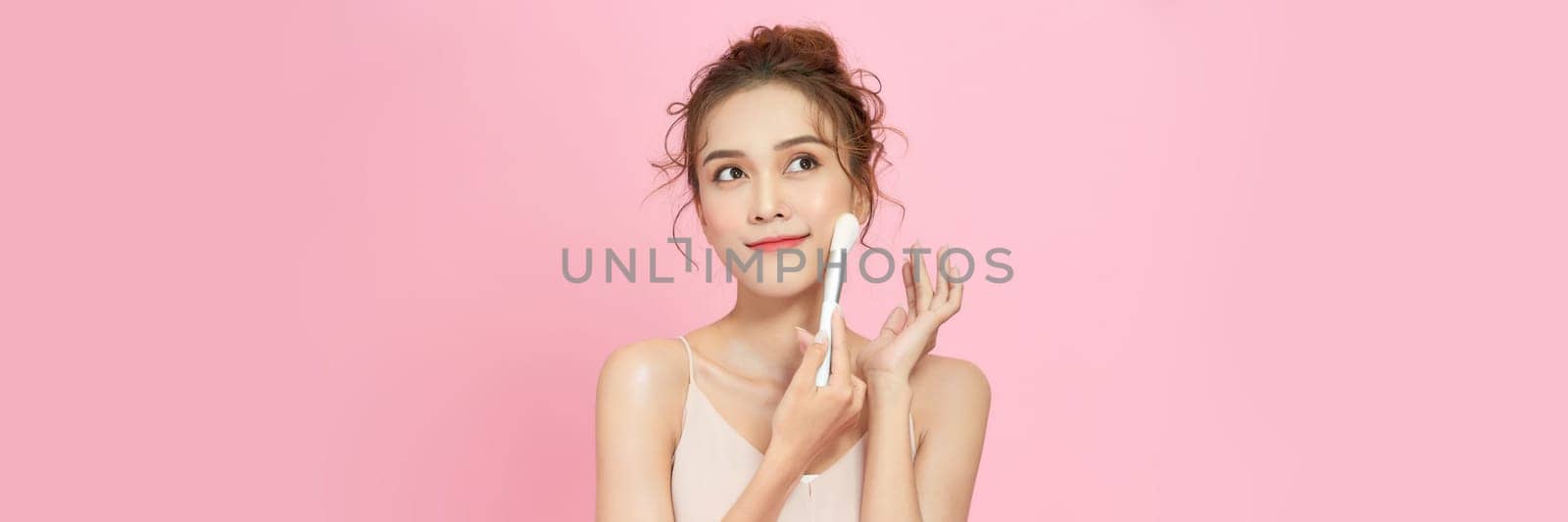 Banner of beautiful happy young girl with perfect skin is holding makeup brush in hand.