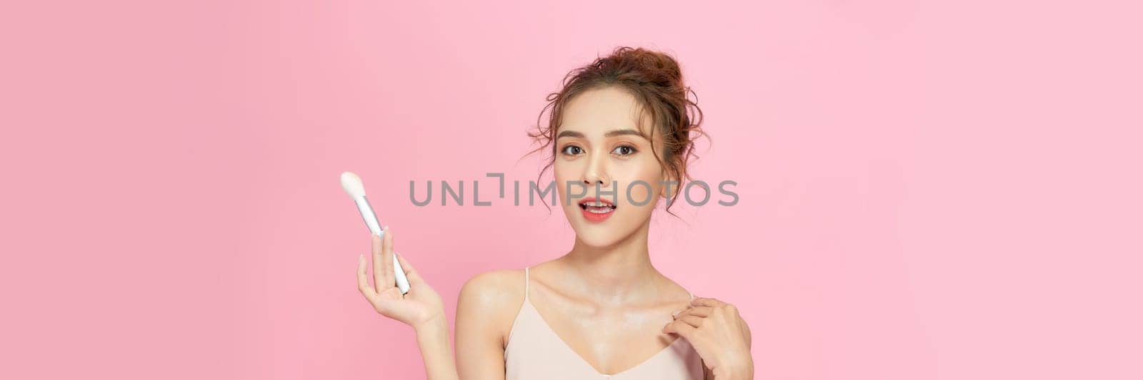 Beautiful Asian young woman smile and holding make up brush with healthy Clean and Fresh skin  by makidotvn