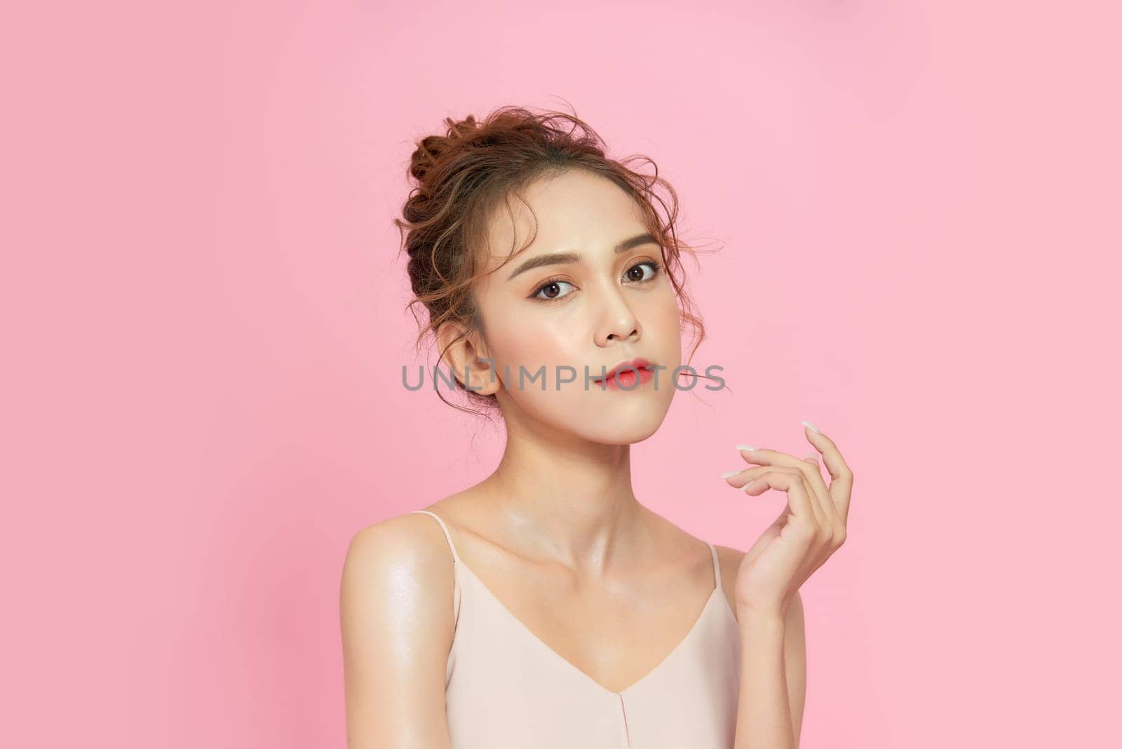 Beautiful young asian woman with clean fresh skin on pink background, 