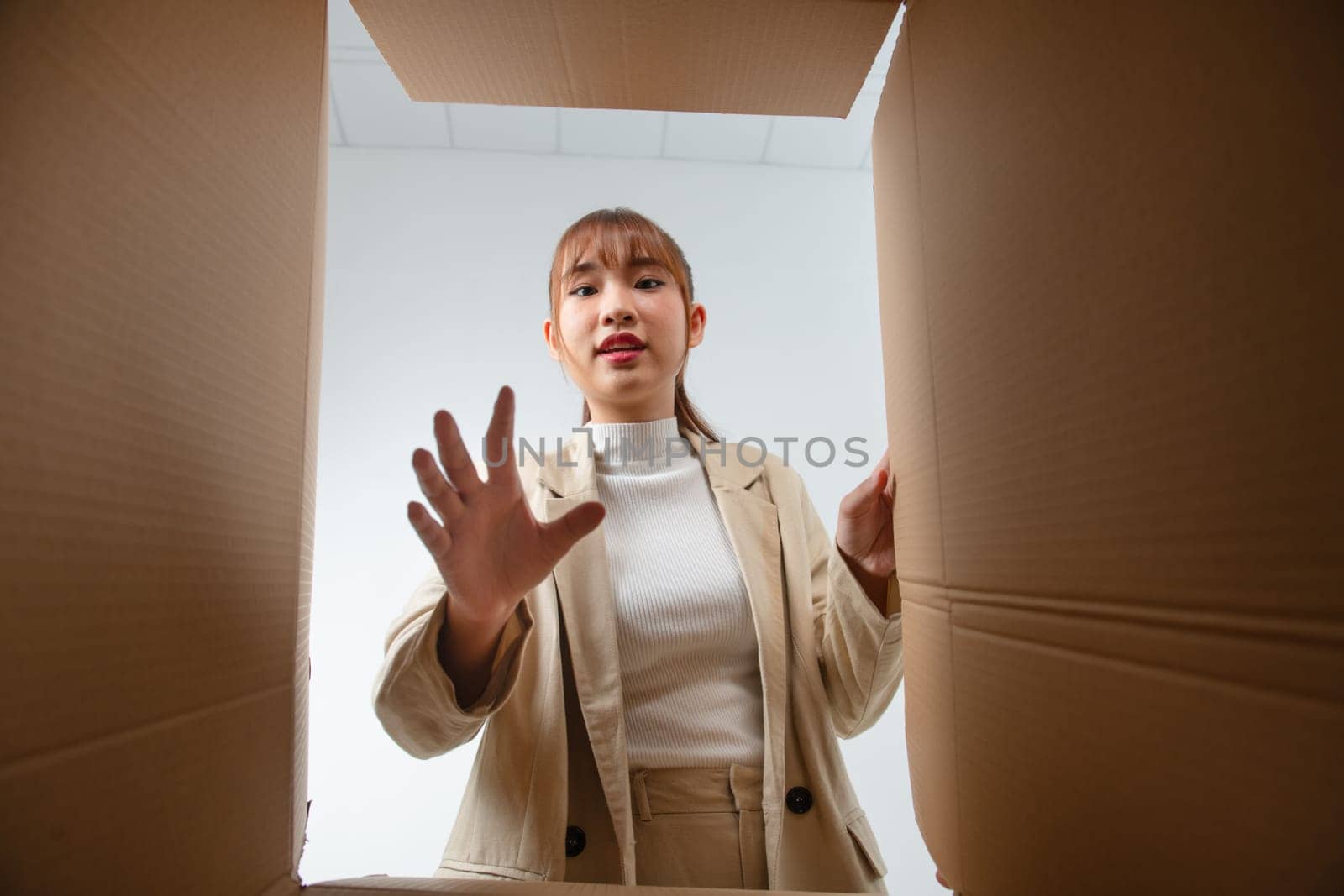 Happy Asian young woman opening carton box from internet store order shopping online at home