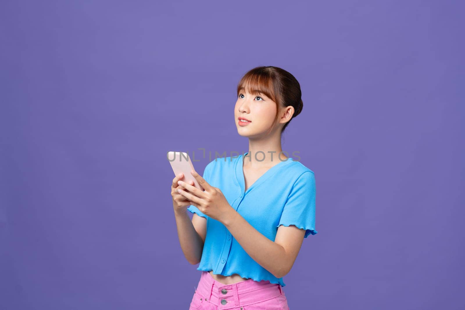 Young beautiful smiling female in trendy summer clothes, holding smartphone by makidotvn