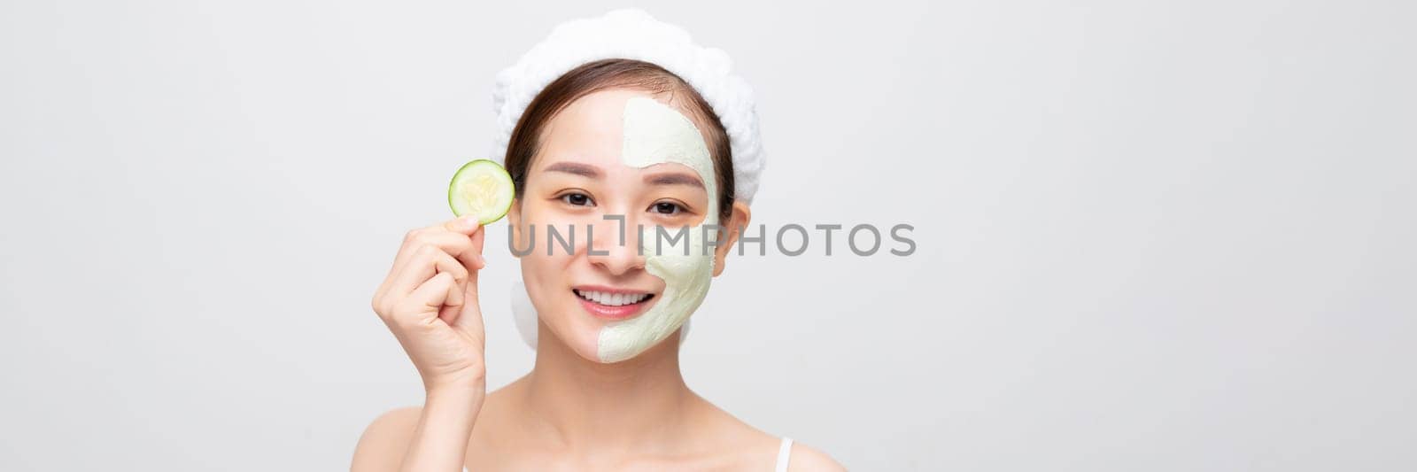 cheerful woman with clay mask on half of face smiling isolated on web banner by makidotvn