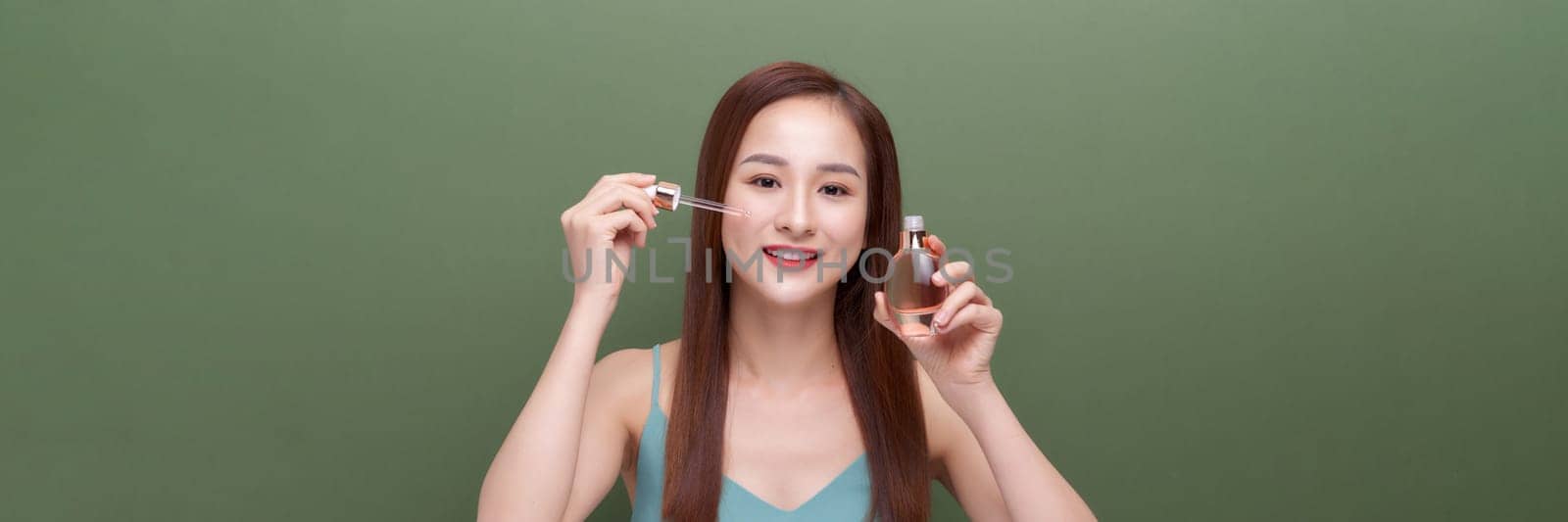 beautiful female using anti-aging treatment product on green,panorama by makidotvn