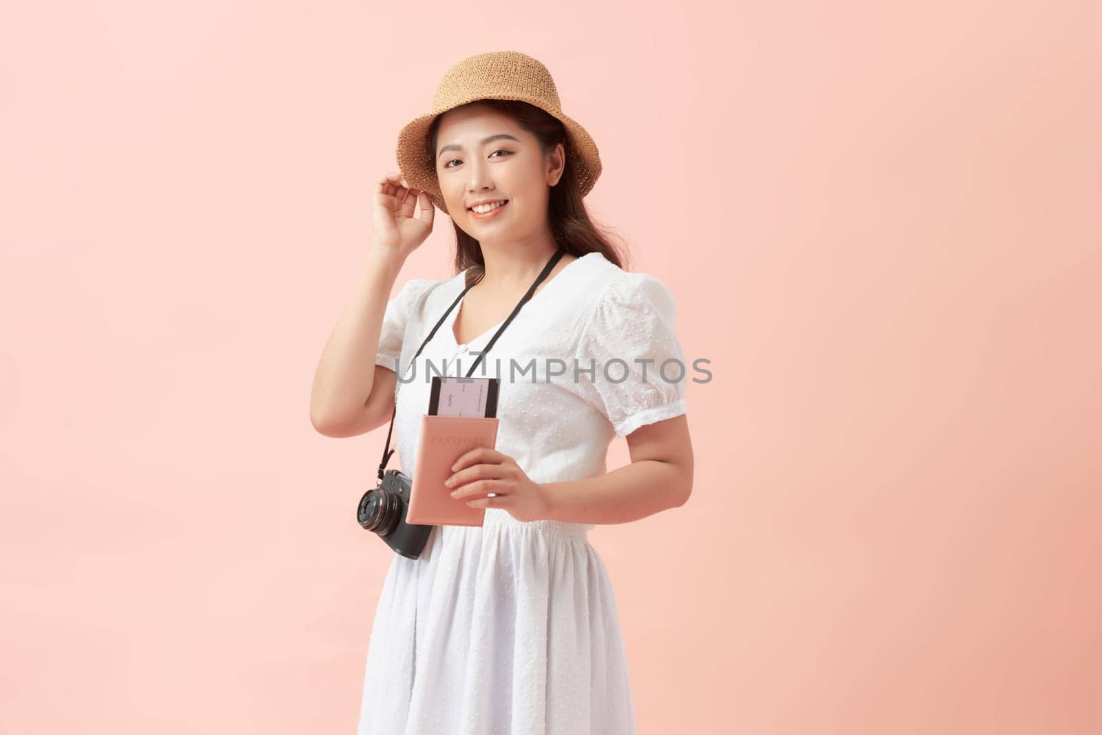 Beautiful travel woman with passport isolated on pink background