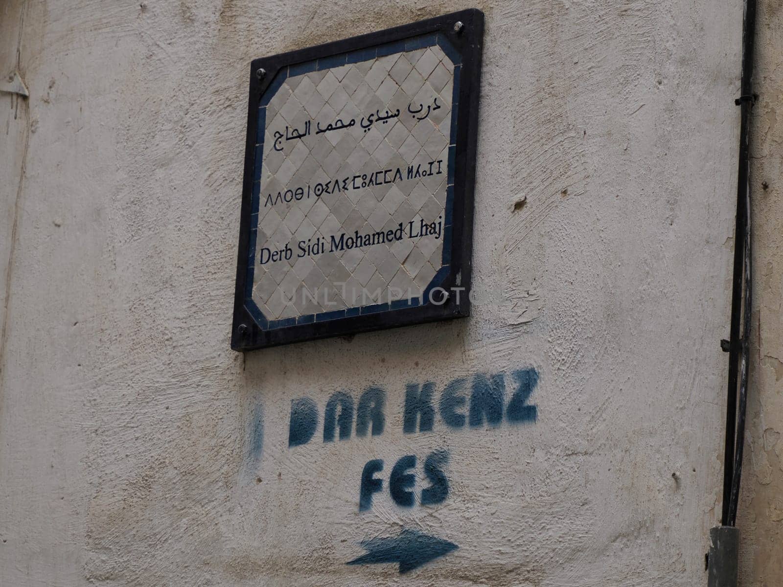 Small street sign tri lingual arabic french and berber in Fez medina (old town). Morocco. by AndreaIzzotti