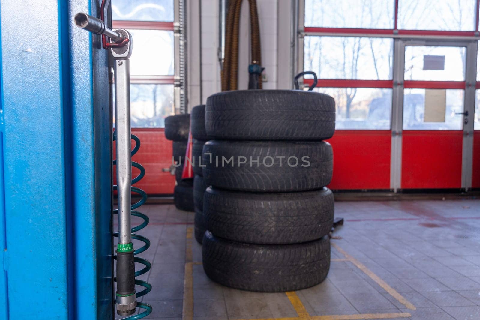 A set of tires for seasonal replacement near the lift in the tire workshop. by BY-_-BY