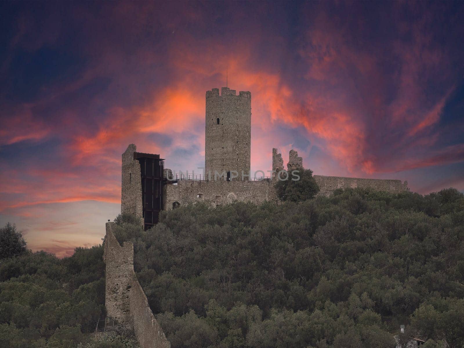 dramatic sunset on Ursino mountain castle in noli medieval village liguria italy by AndreaIzzotti