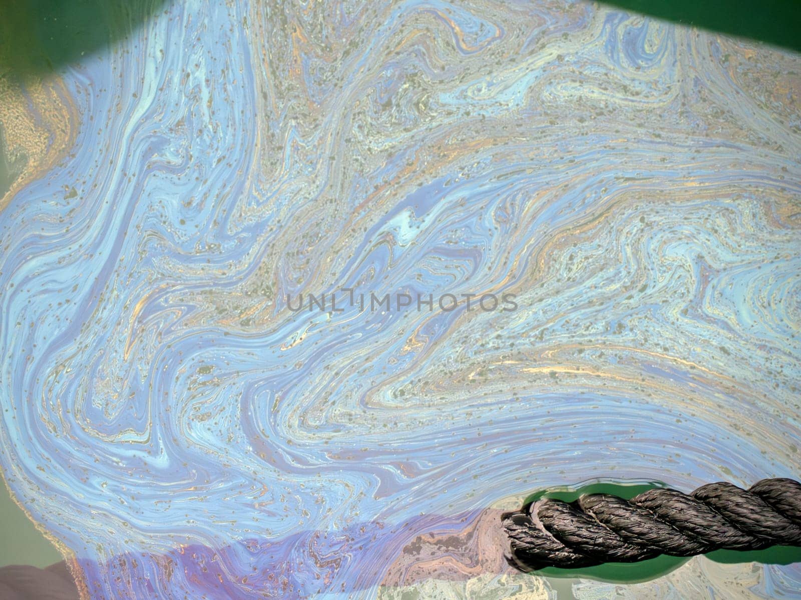 oil spreading on sea surface Aerial top down view like a abstract painting with the rainbow-colored oil spill pattern detail