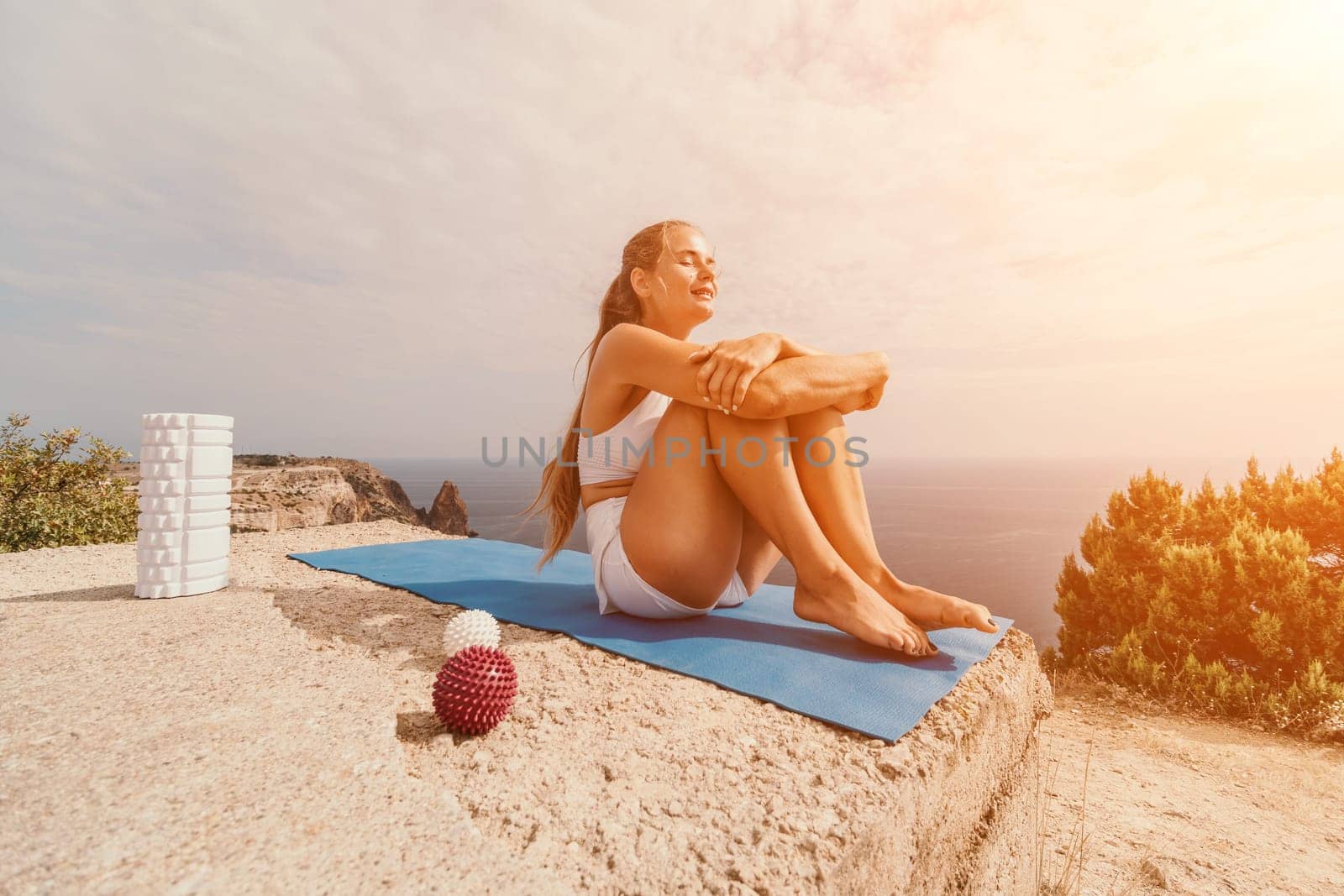 Woman sea pilates. Sporty happy middle-aged woman practices pilates on a beach near the sea, promoting a healthy lifestyle through outdoor fitness and meditation. by panophotograph