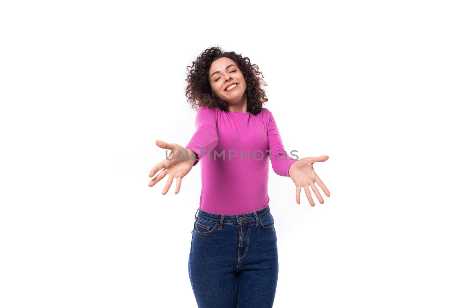 young curly brunette lady is dressed in a trendy lilac turtleneck on a white background.