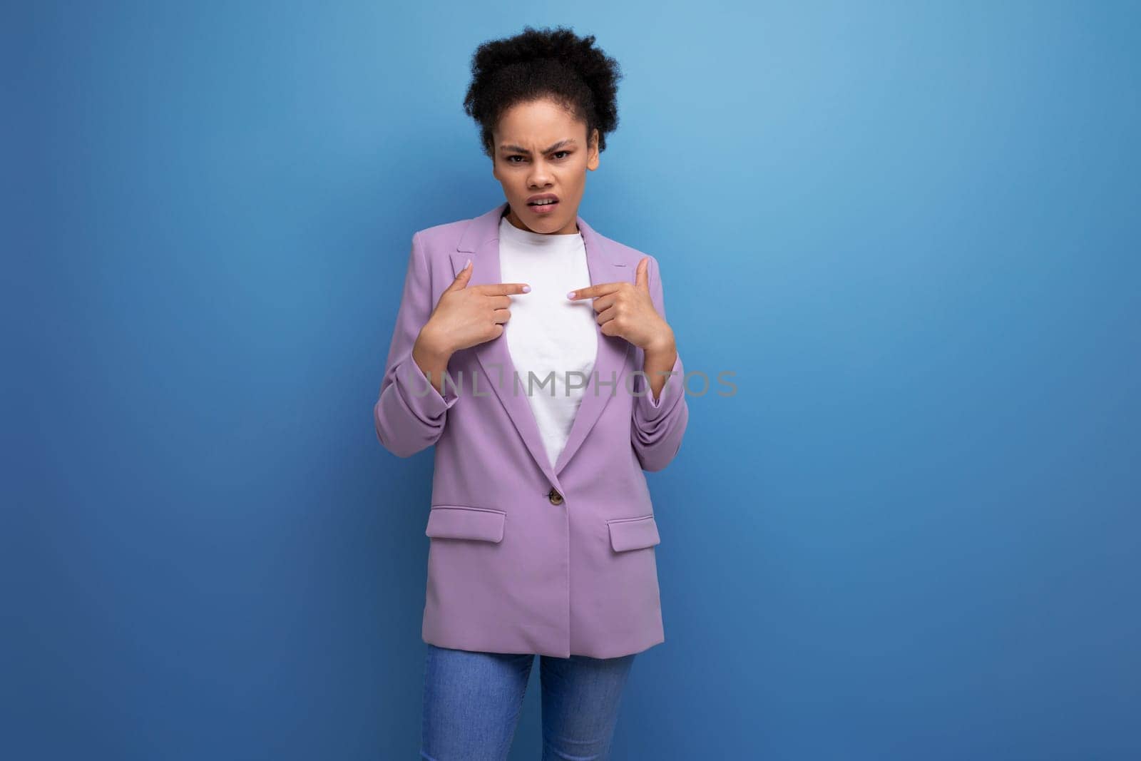 young successful hispanic brunette leader woman dressed in jacket on studio background with copy space.