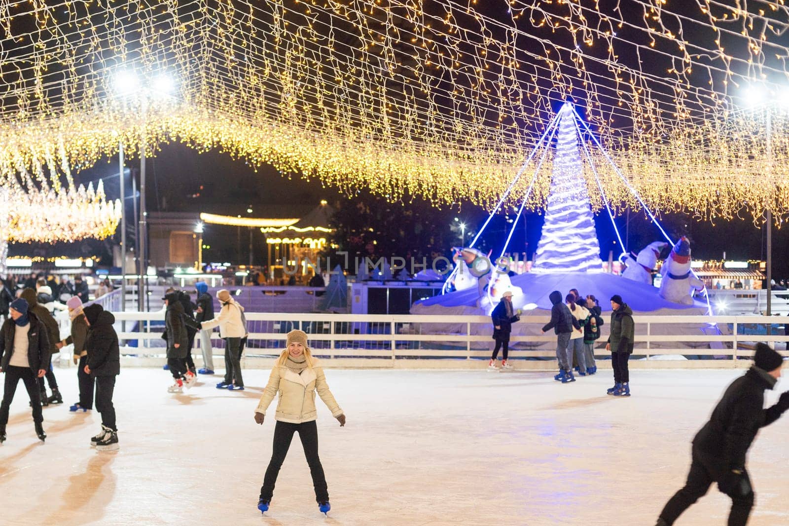 Kyiv, Ukraine - 03.12.2023: Winter night at the ice rink people ice night lights. High quality photo